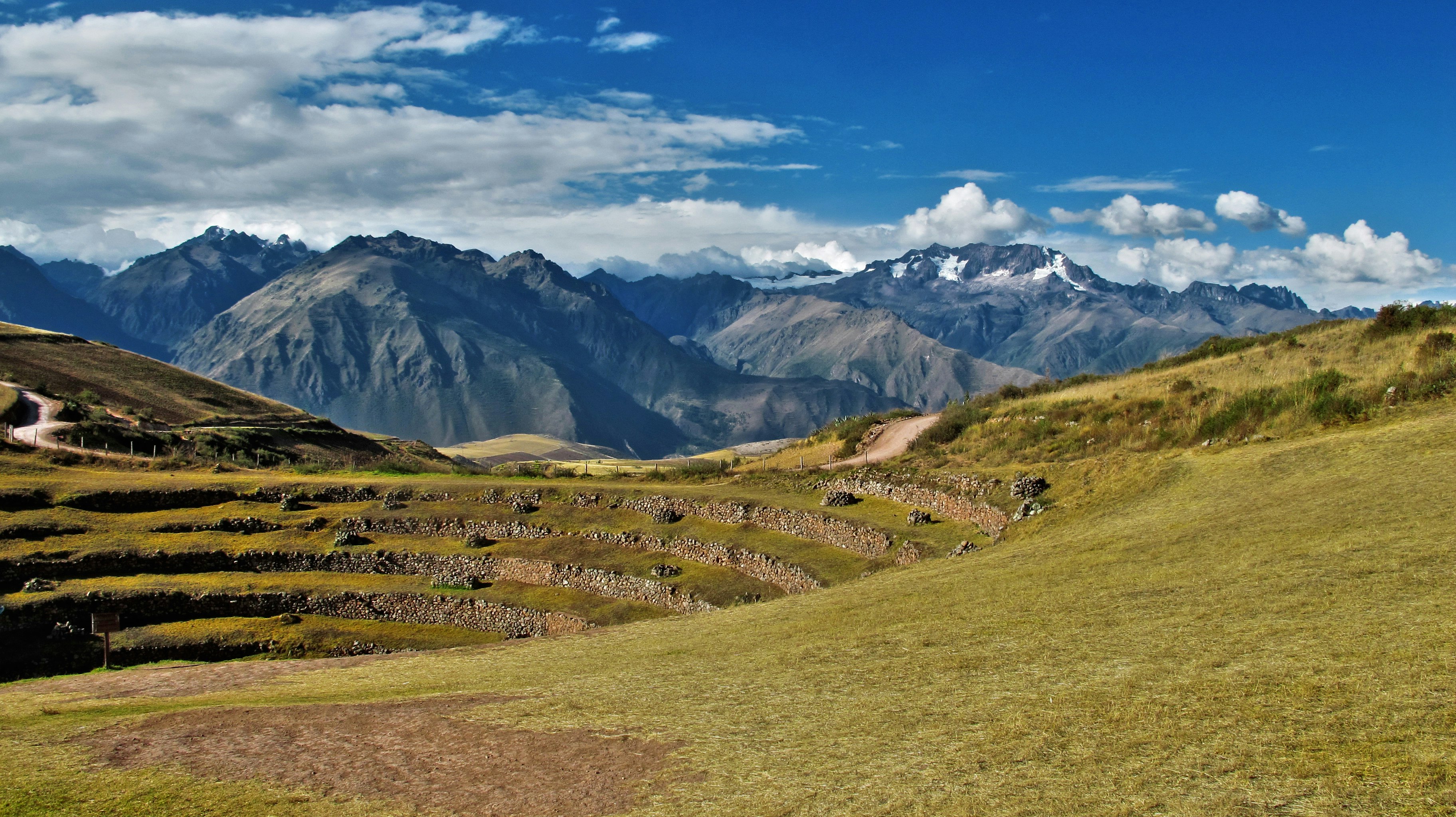 landscape photography of mountain under white clouds and blue sky